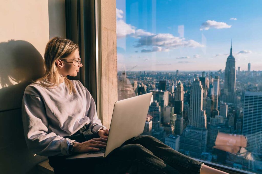 Woman looking out at the New York skyline from her apartment